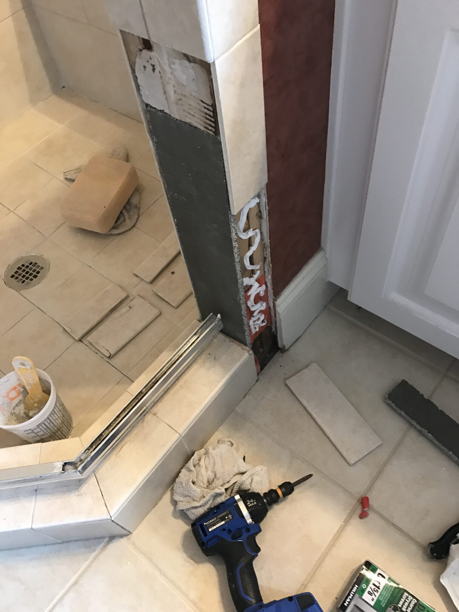 Demolition of leaking shower tile preparing for tile replacement